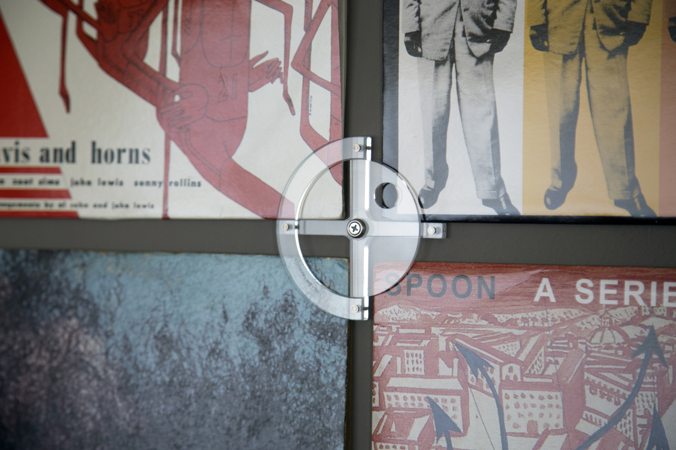 Single Spinmount unit holding four vinyl records on a wall.